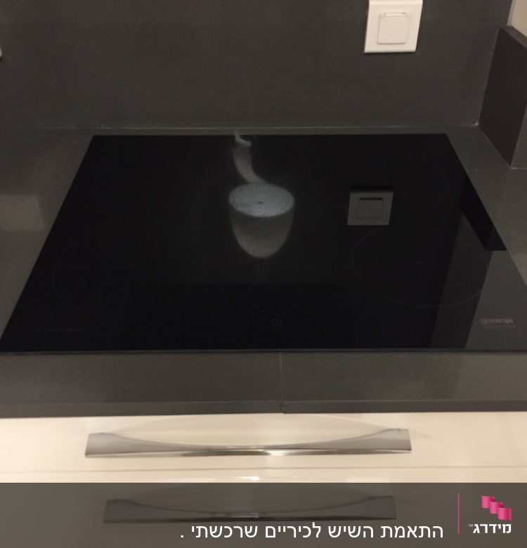 כיריים חשמליות על משטח שיש אפור במטבח מודרני